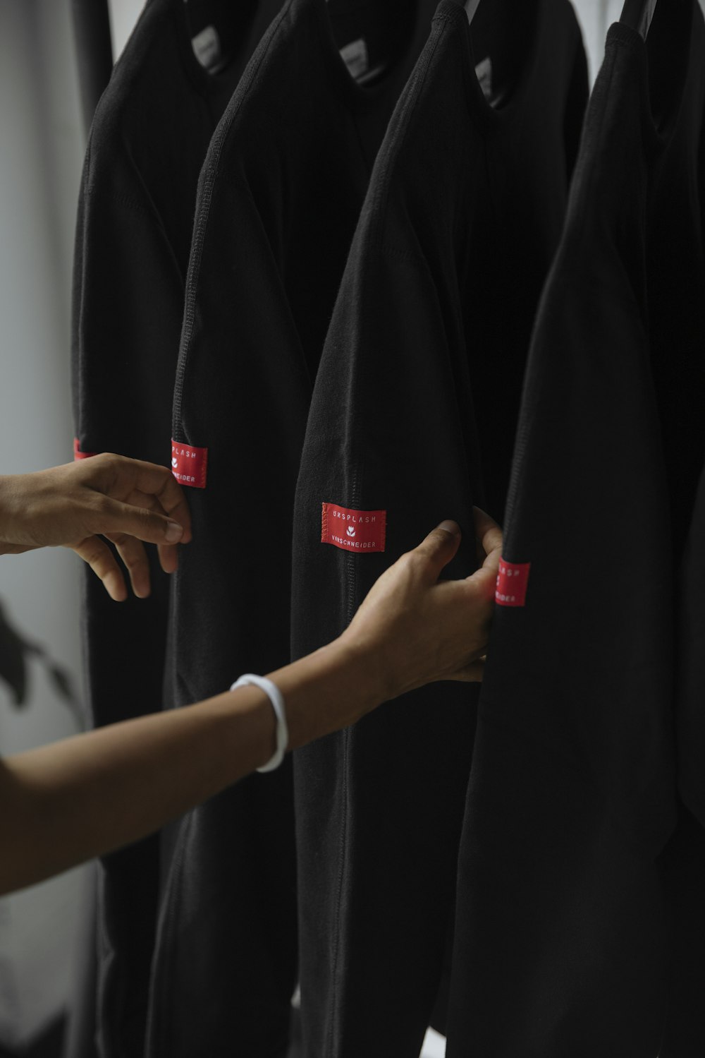 person holding black jackets inside room