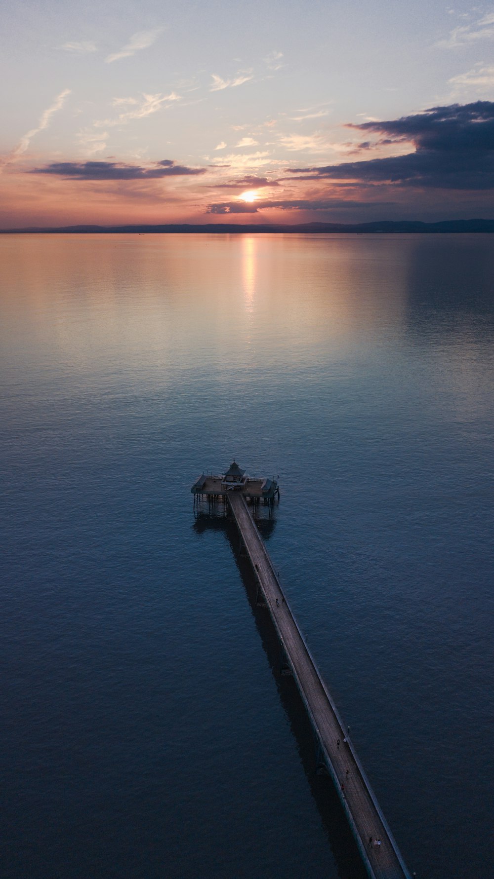 brown wooden pier dock on body of water during golden hour