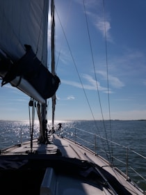 Professional naval surveyor inspecting a sailboat on calm waters.