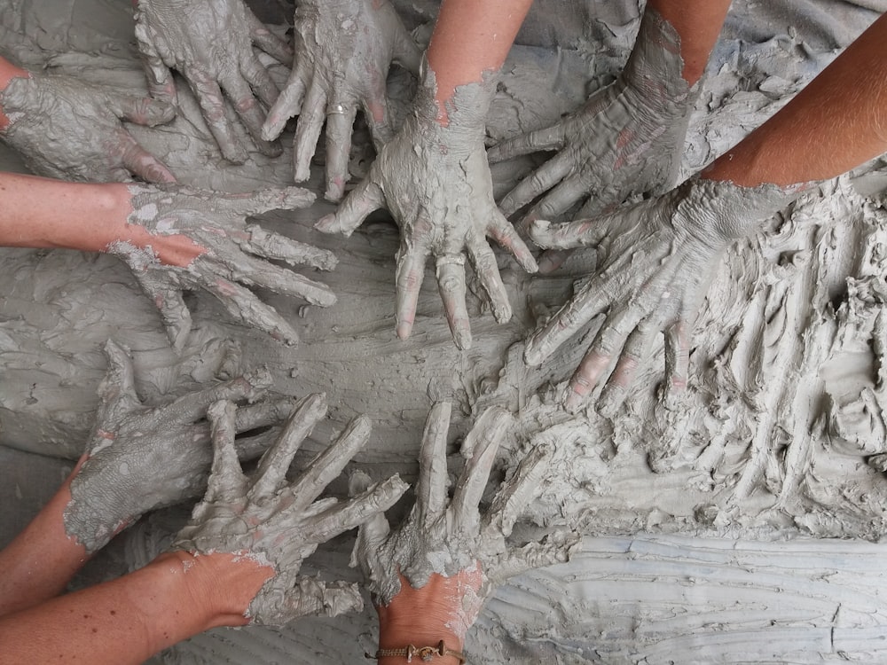 la mano della gente sul fango grigio