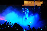 A smiling solo singer holding the mic, immersed in their favorite song with a backdrop of vibrant screens.