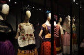 A collection of finished embroidered costumes displayed on mannequins.
