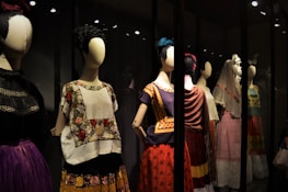 A collection of finished embroidered costumes displayed on mannequins.