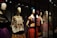 A collection of mannequins adorned with traditional, colorful dresses, featuring elaborate patterns and textiles. Each mannequin has a distinctive hairstyle and pose, creating a sense of cultural heritage and artistic expression.