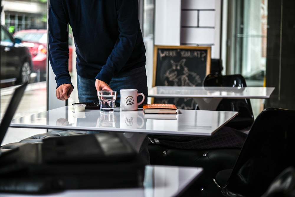 standing person holding glass of water on beside table