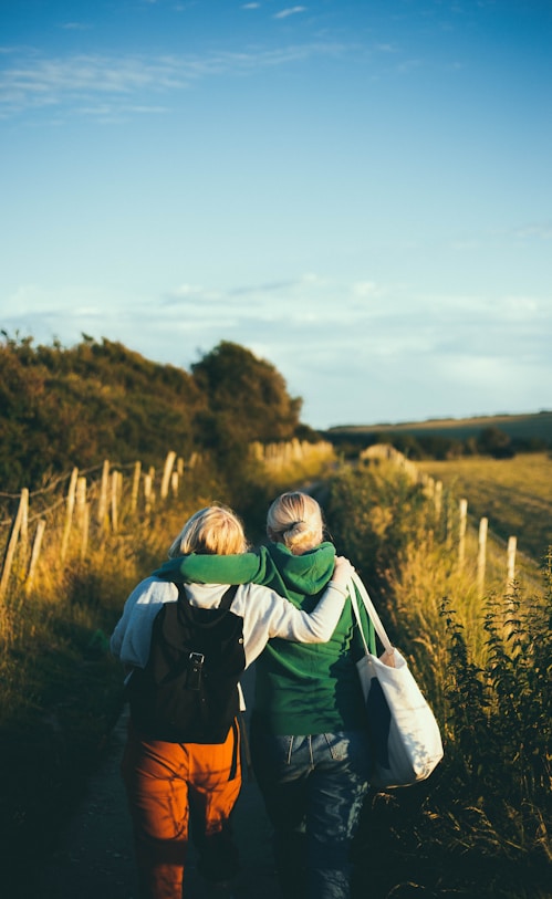 two women walking together outdoor during daytime