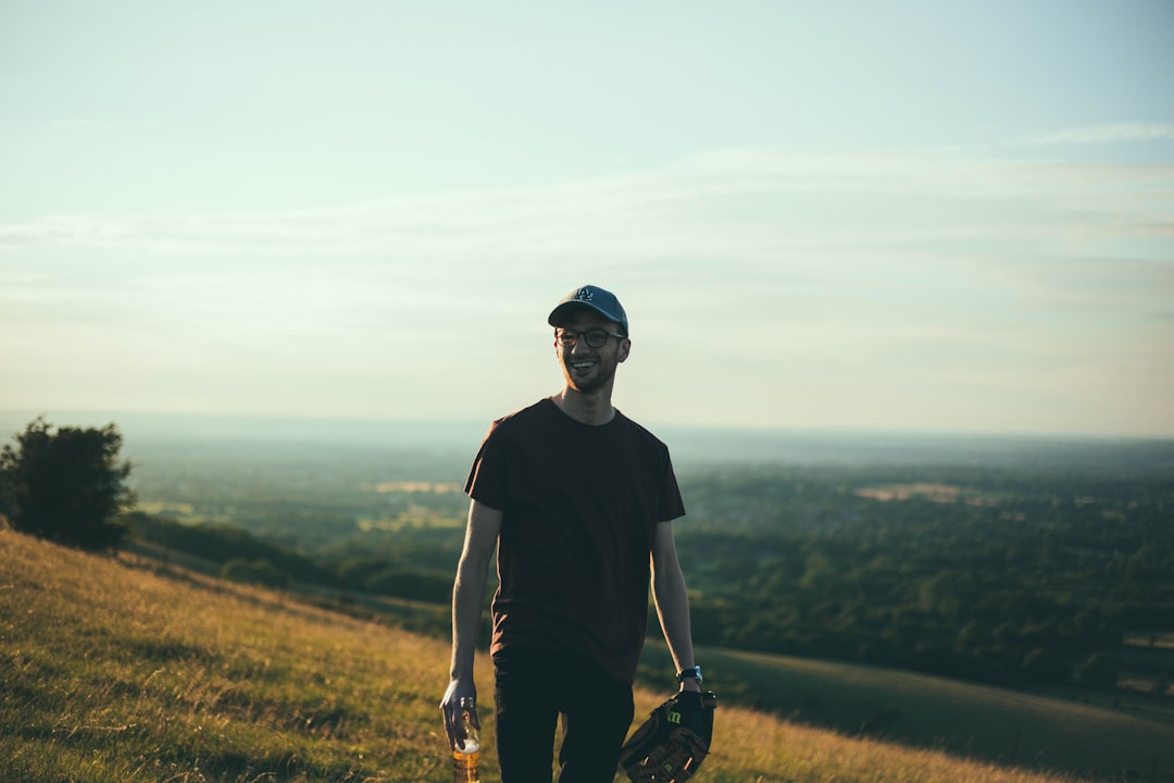 selective photography of man standing on grass field