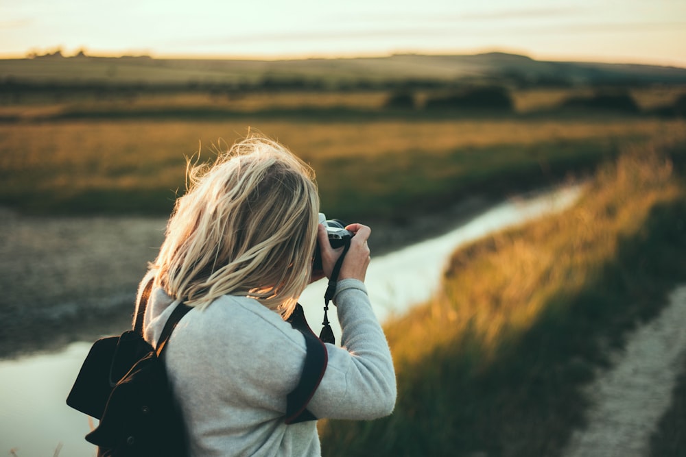 selective focus photography of woman taking picture during daytime