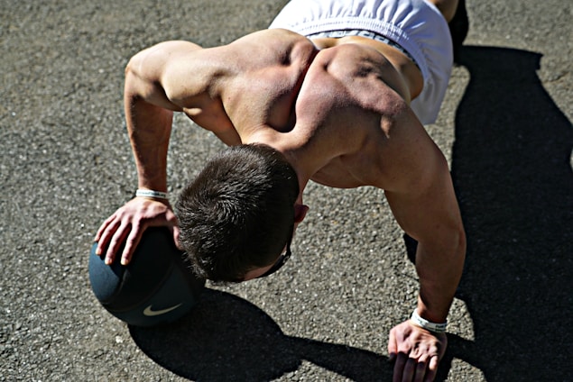 A focused athlete performing a dynamic calisthenics move outdoors at sunrise.