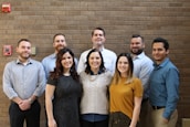 A friendly team of chimney professionals standing together in front of a service vehicle.