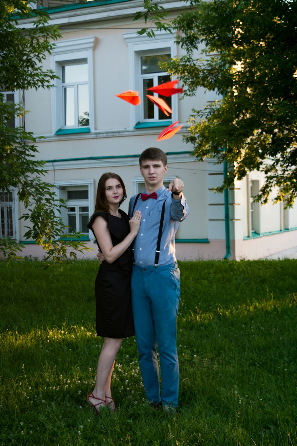 candid photography of woman beside man throwing paper planes