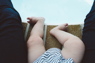 дитячі ніжки, боді в білі та сірі смужки