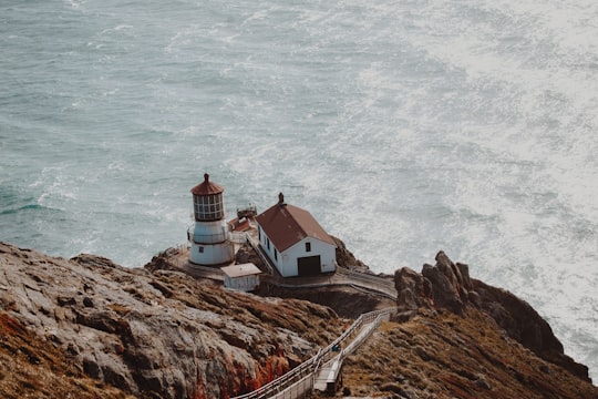 aerial photography of white and brown concrete house beside lighthouse on gray mountain cliff near body of water at daytime in Point Reyes National Seashore United States