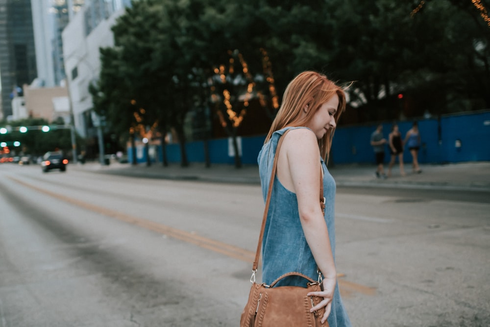 woman crossing the street during daytime photo