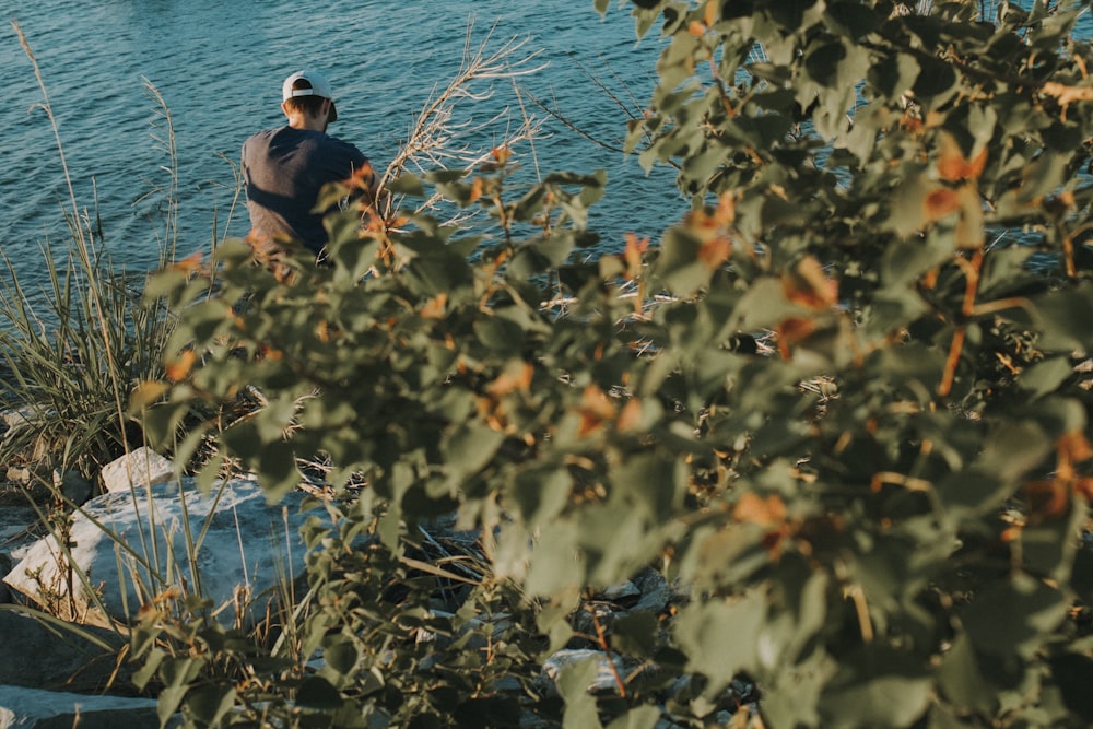 man sitting near body of water