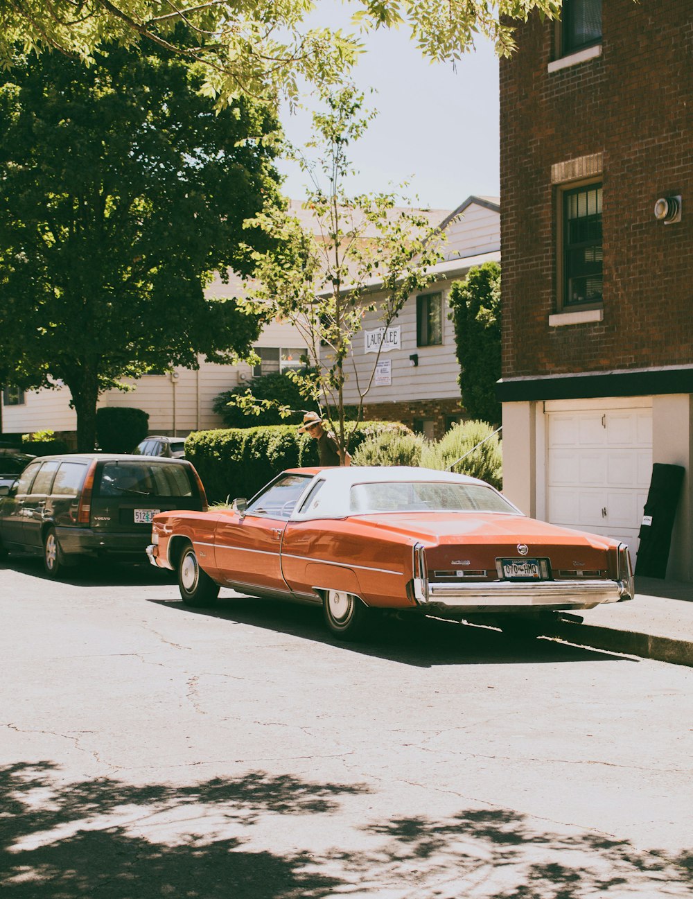 beige coupe park near brown high-rise building