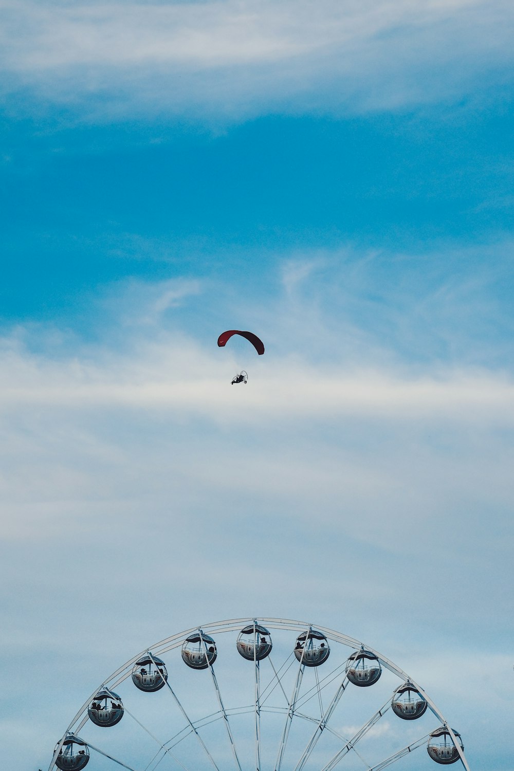 aerial photography of person parachuting above ferris wheel