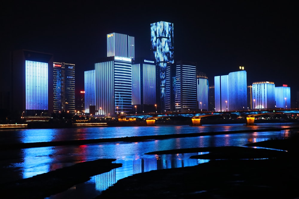 fotografia de edifícios iluminados refletindo sobre a água