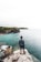 man standing on white and brown rock seeing horizon during daytime