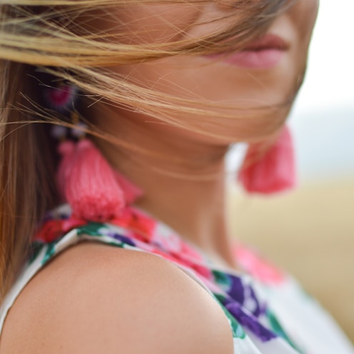 close-up photo of woman wearing white, pink, and purple floral sleeveless dress