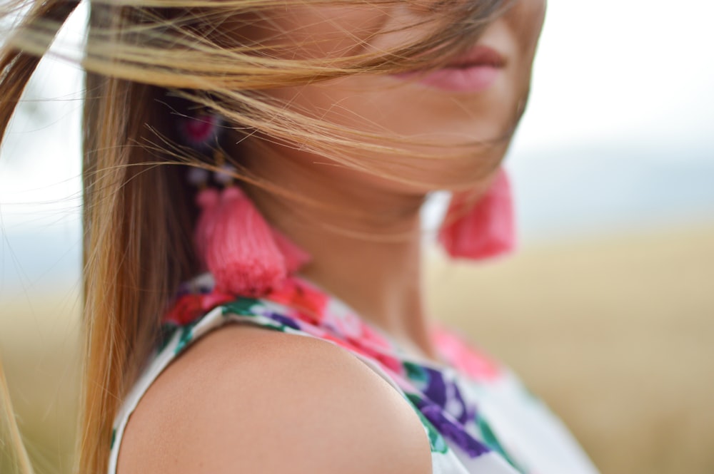 close-up photo of woman wearing white, pink, and purple floral sleeveless dress