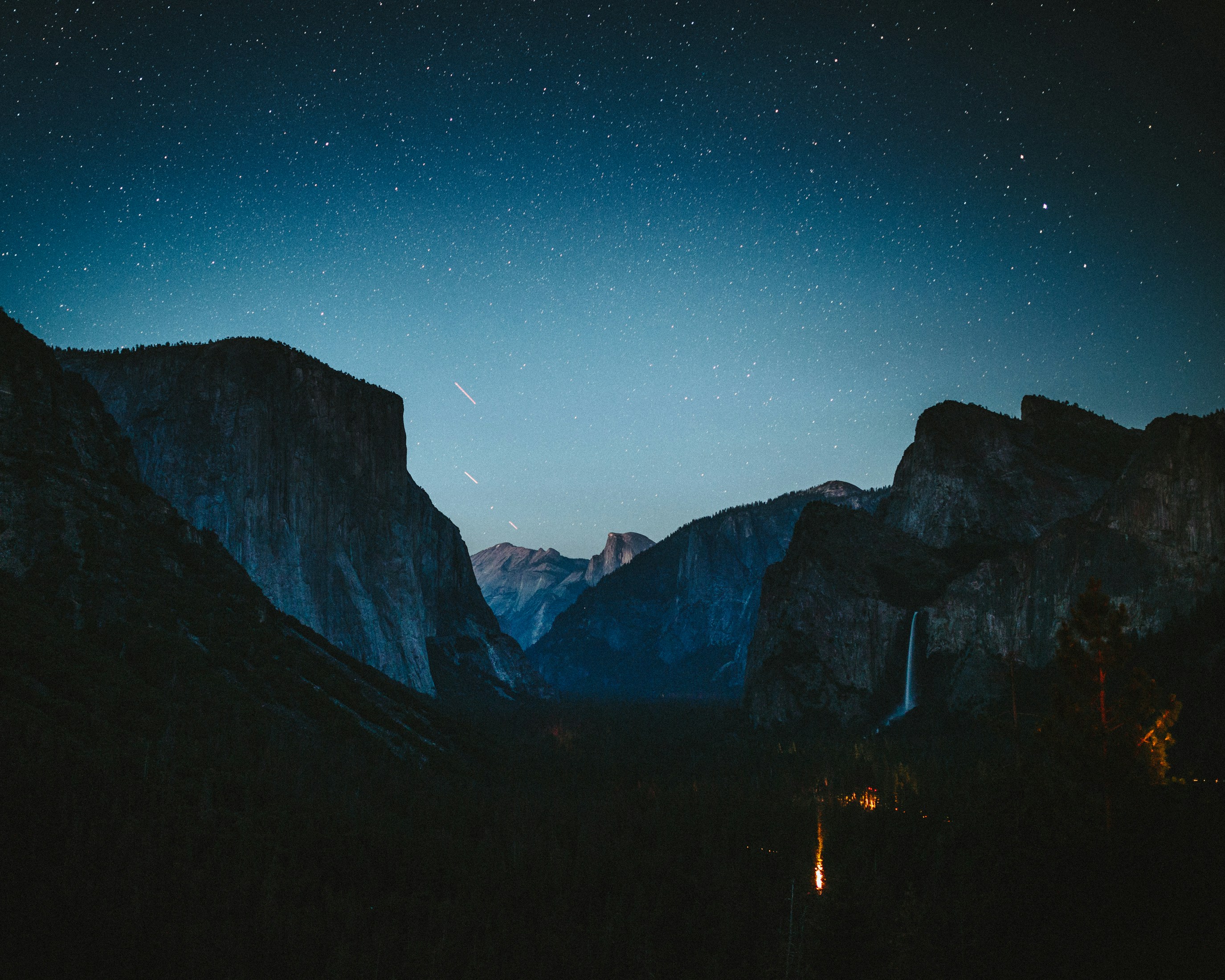 silhouette of mountains under blue sky during night time