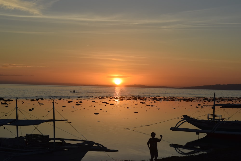 silhouette of man standing on seashore