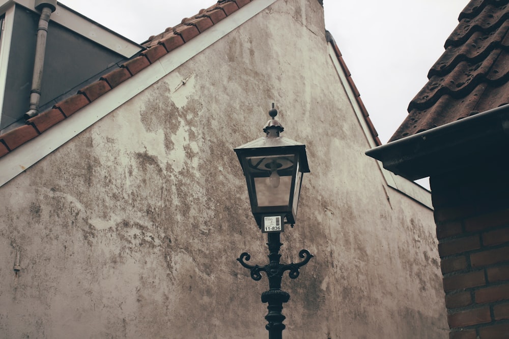昼間、2軒の家の近くにある黒いスチール製の街灯柱