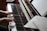 A pair of hands gracefully playing the keys of an upright piano. Sheet music is visible on the music stand, and the polished wooden finish of the piano adds a classic touch.