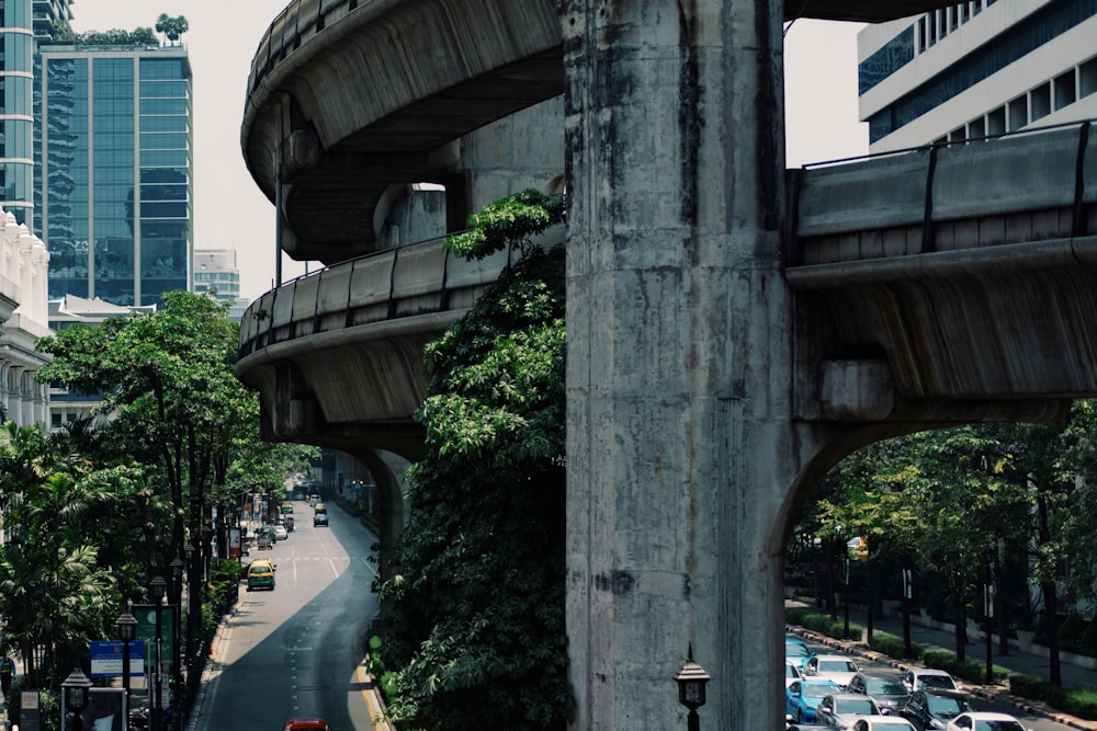 gray concrete flyover beside heavy traffic road at daytime