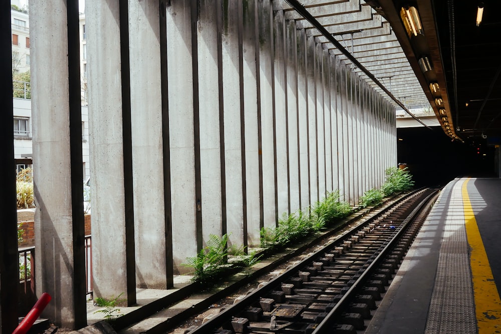 graue Betonstraße neben Bahnschienen