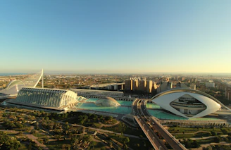 A panoramic view of a modern mixed-use development showcasing sleek architecture and lush landscaping under a clear sky.