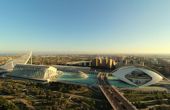 A panoramic view of a modern mixed-use development showcasing sleek architecture and lush landscaping under a clear sky.