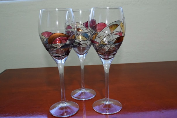 A collection of unique, artistically designed wine glasses with colorful patterns.