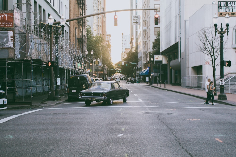 Coche en carretera entre edificios