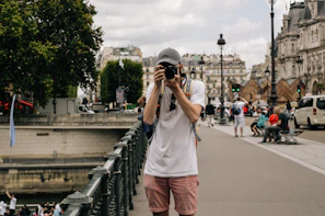 Traveler taking photos of a historic European landmark, immersed in the experience.