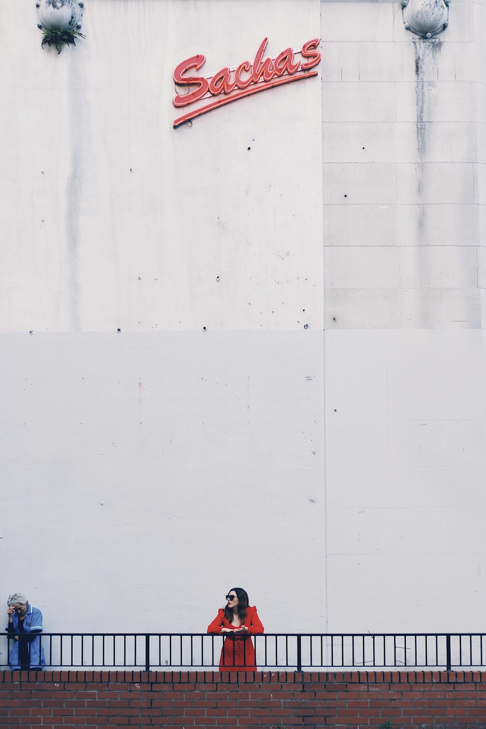 woman in handrail under Sachas signage