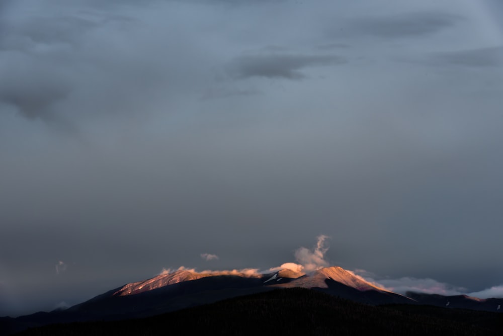 montagna marrone sotto il cielo grigio durante la fotografia diurna