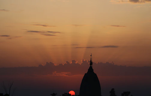 A serene view of the temple's golden dome glowing at sunset.