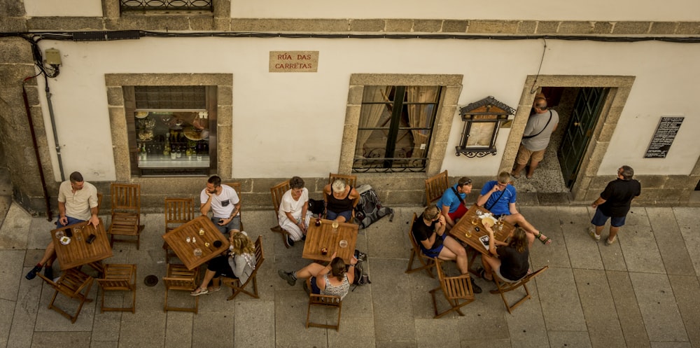 gruppo di persone che si siedono sulla sedia di legno marrone