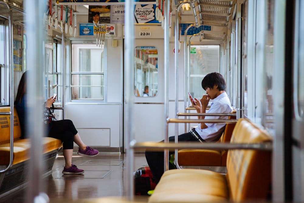 man and woman sitting chair inside the train