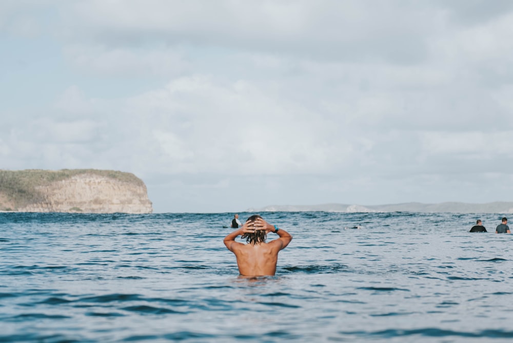 man swimming near ocean during daytime