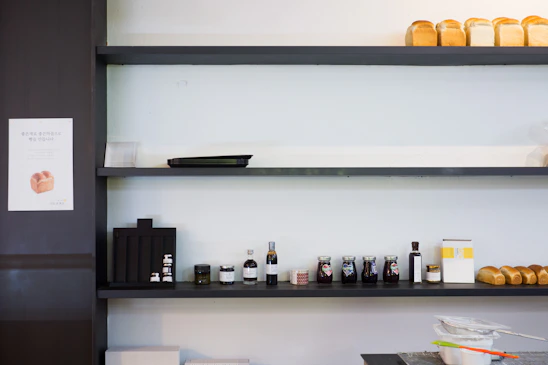 A clean, minimalist workspace with baking tools and fresh pastries arranged neatly on a warm beige surface.
