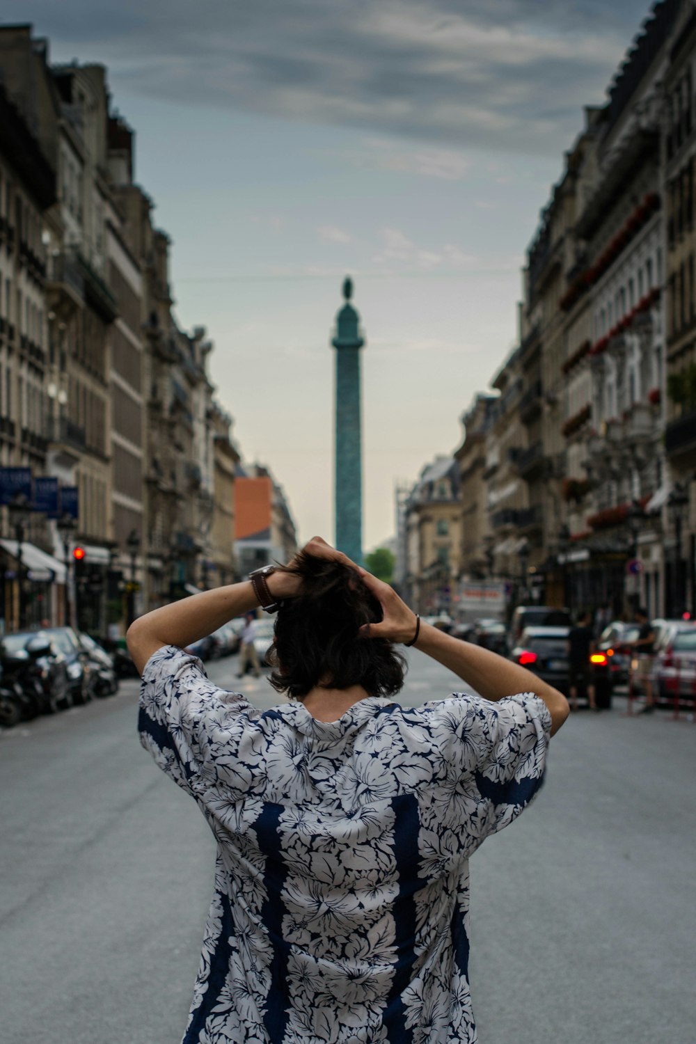 Vista trasera del hombre que lleva una blusa floral mientras se arregla el pelo