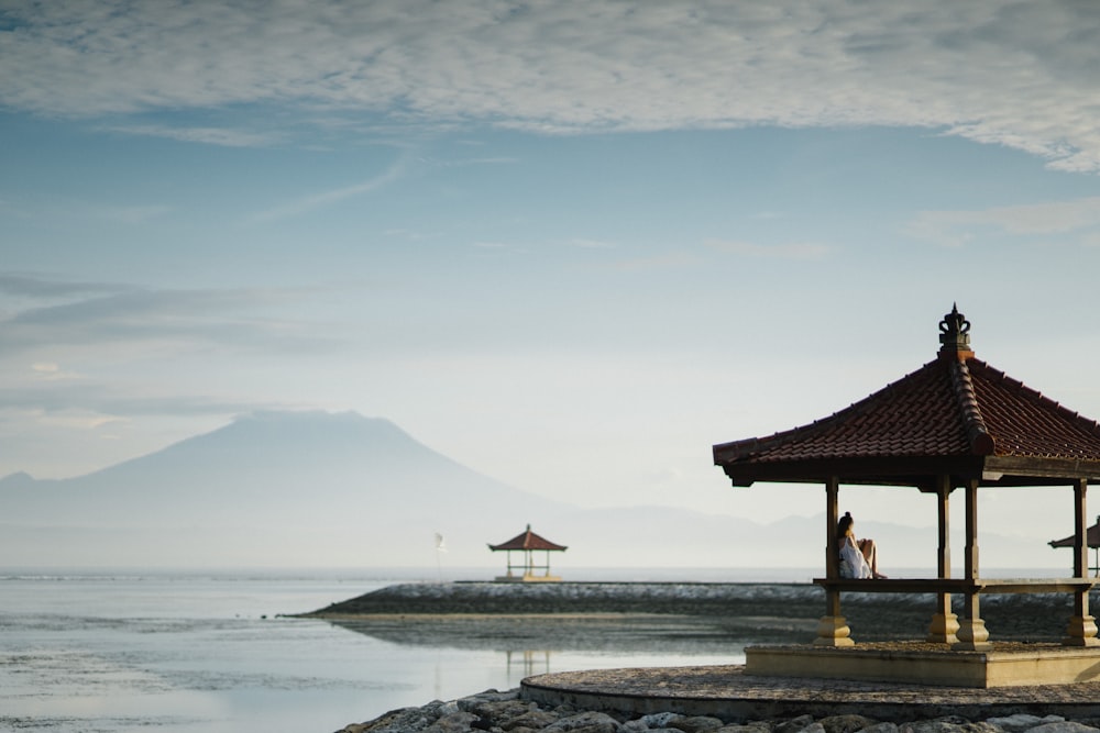 brown gazebo near sea closeup photography