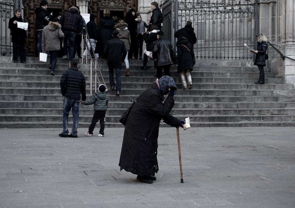 woman in black dress holding brown walking cane