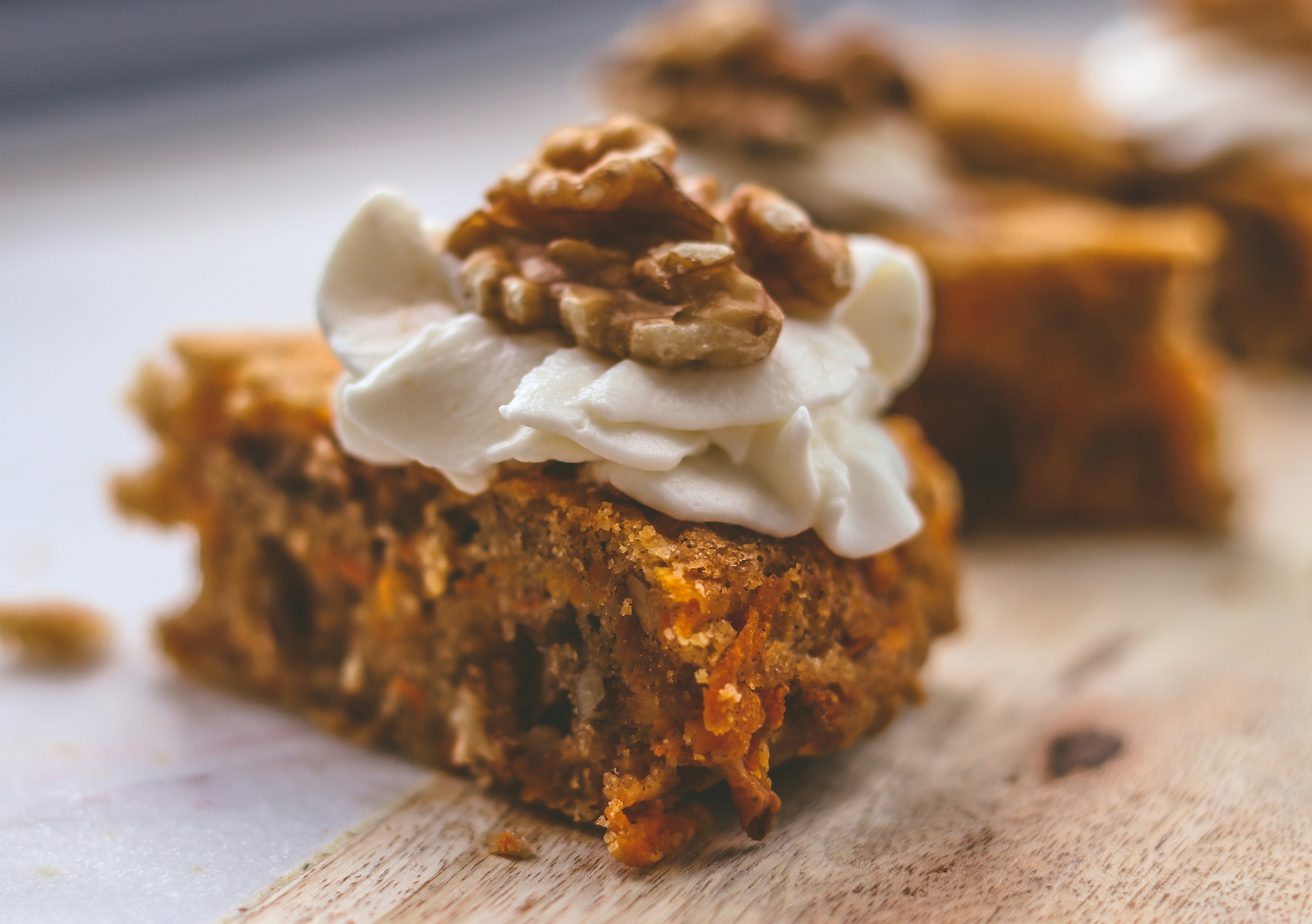 Carrot cake slice showing moist layers with cream cheese and walnut praline