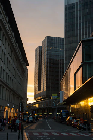 A vibrant city street at sunset with warm golden light reflecting off the buildings.