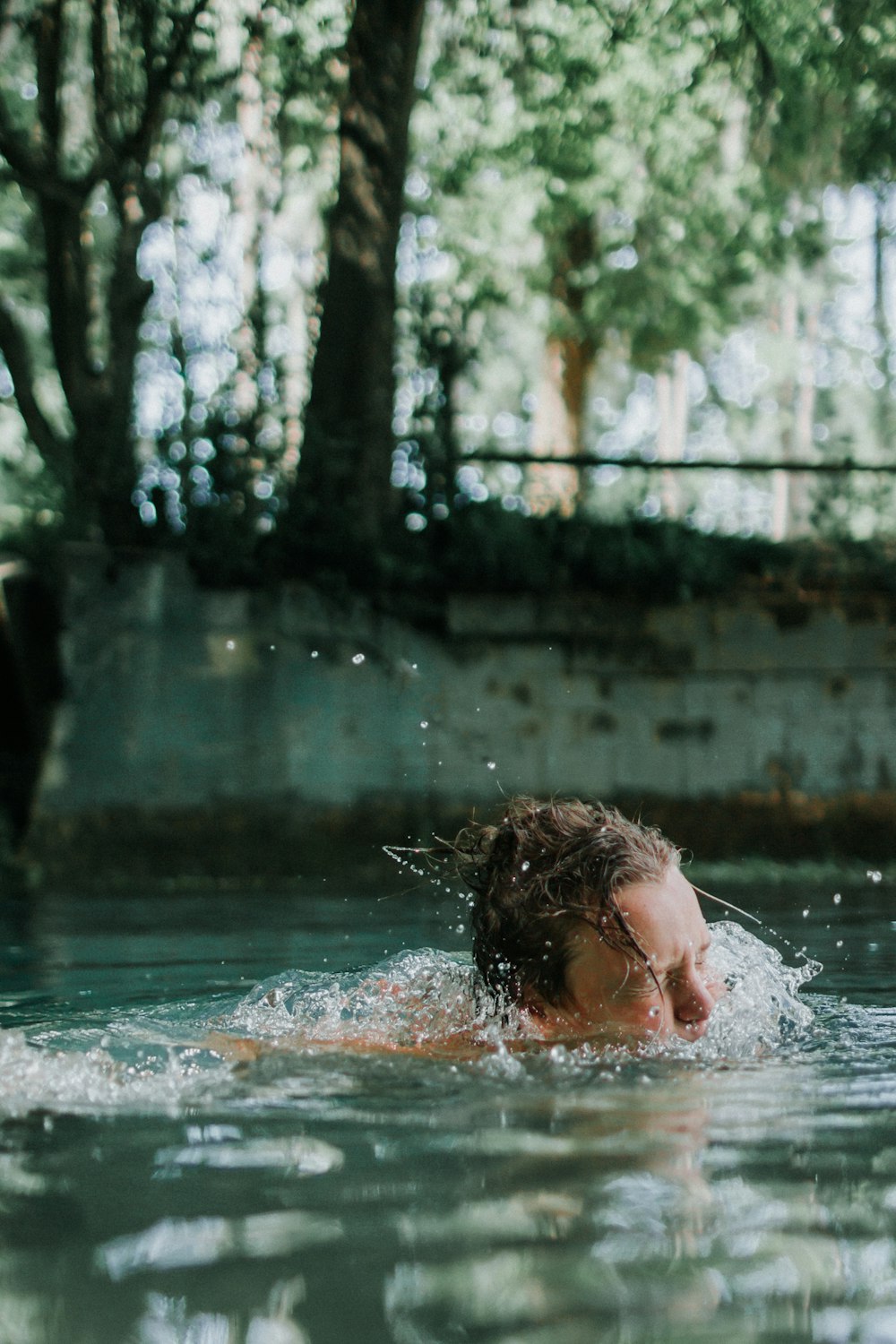 mulher nadando no corpo da água durante o dia
