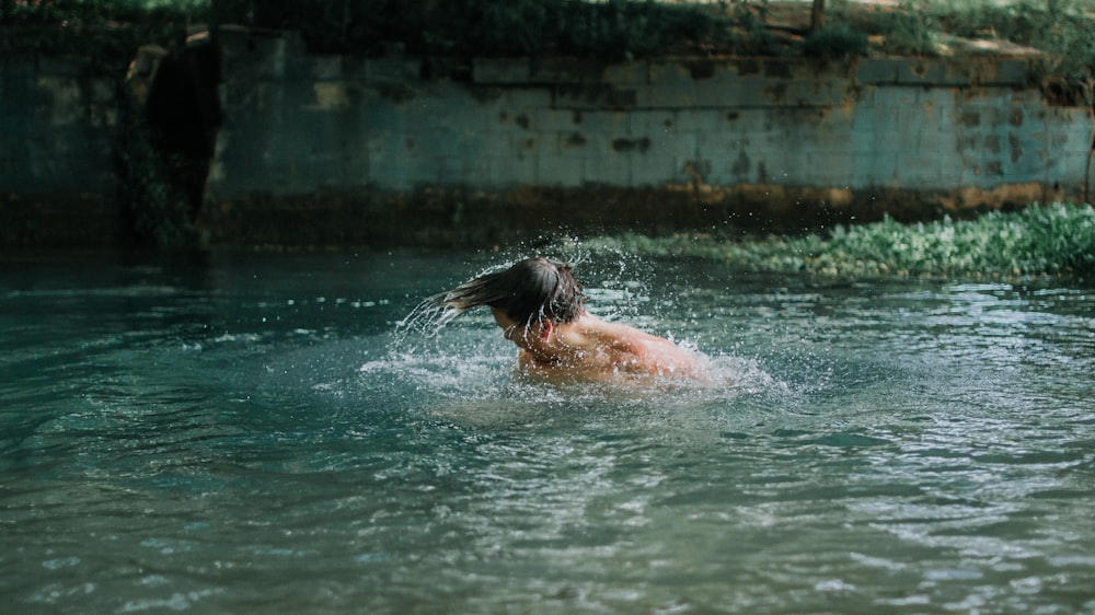 昼間、水の上を泳ぐ男性